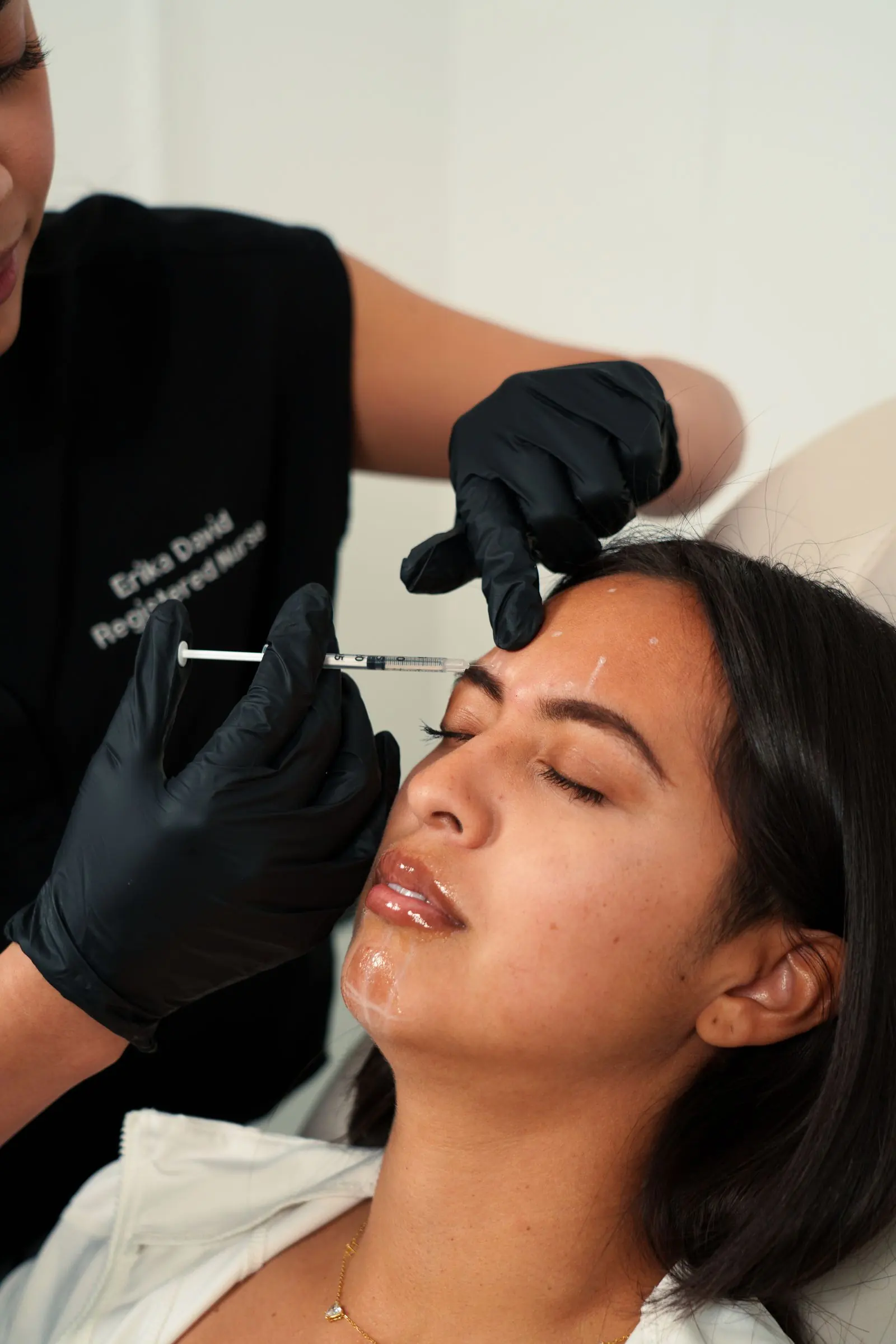 Professional administering a Botox injection to a client's forehead